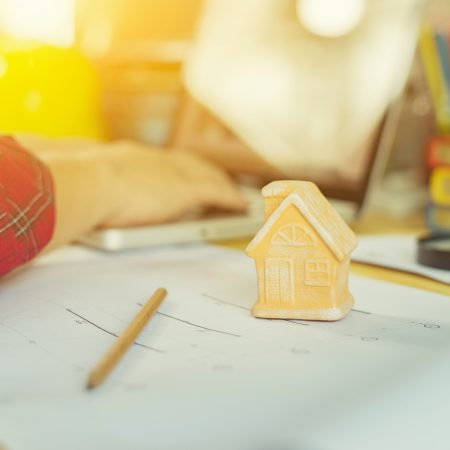 home model with architect man working with laptop and blueprints,engineer inspection in workplace for architectural plan,sketching a construction project,selective focus,Business concept vintage color